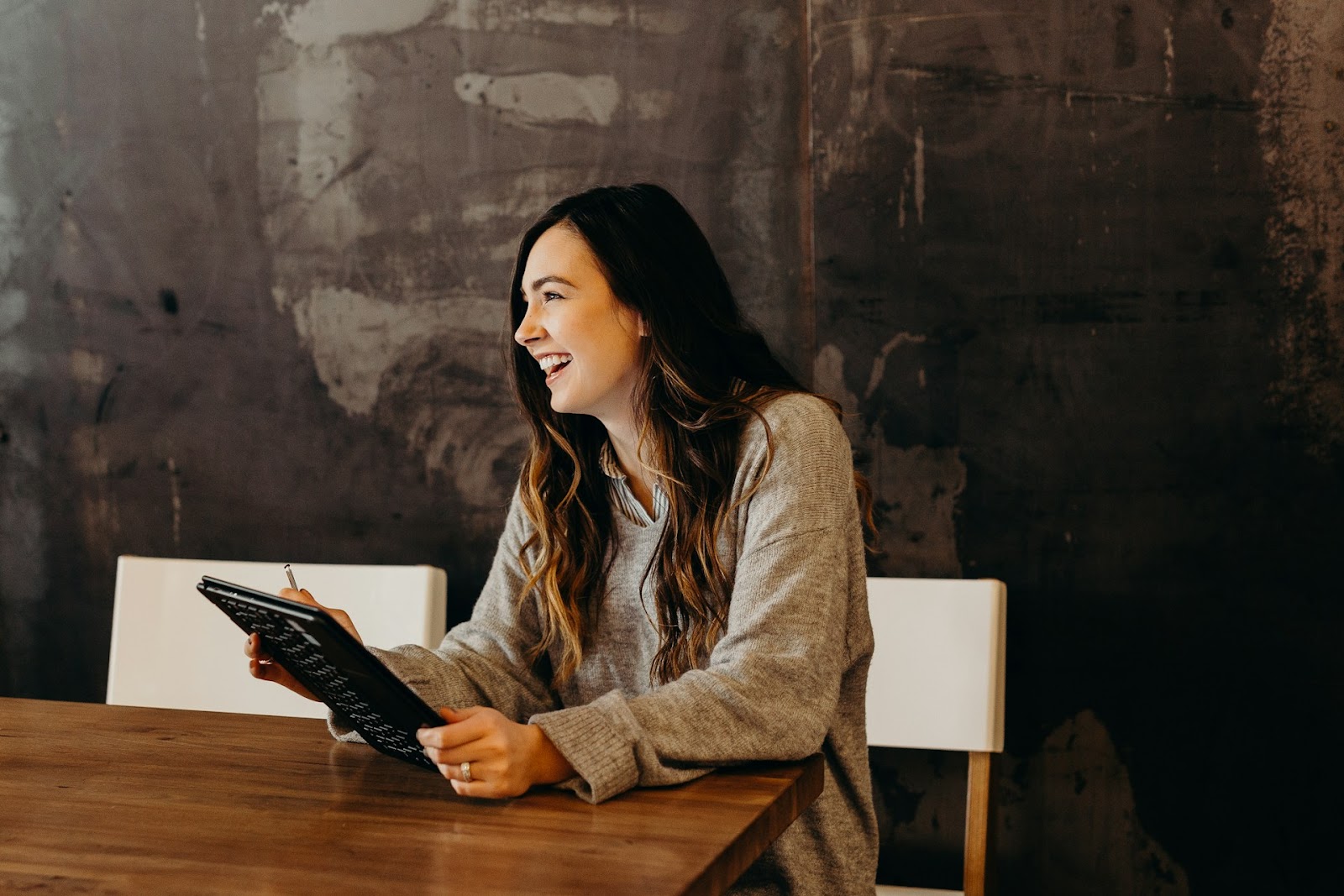 A female business owner smiles at a table using a tablet